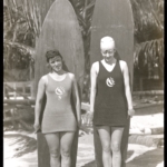 Real Photo Two female member of the Los Angeles Athletic Club stand in front of surfboards at Waikiki